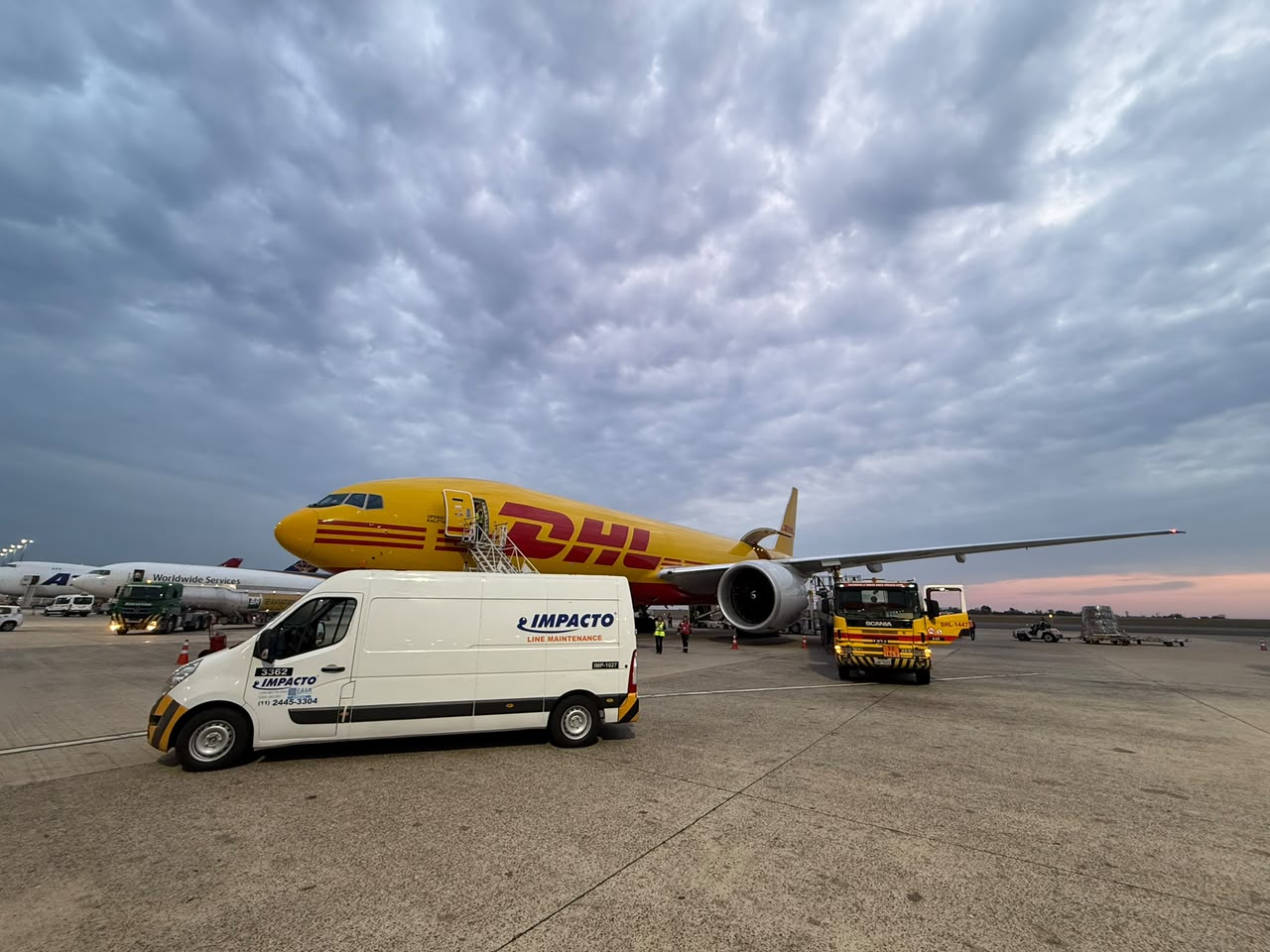 Vehículo de mantenimiento de línea de Impacto Aviation junto a una aeronave de DHL