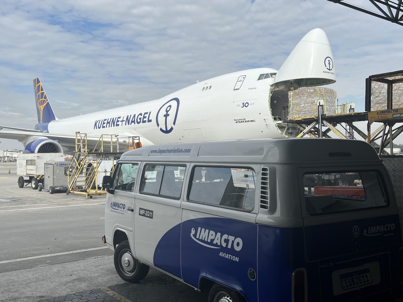 Furgoneta de Impacto Aviation junto a una aeronave de carga operada por Atlas Air durante la carga