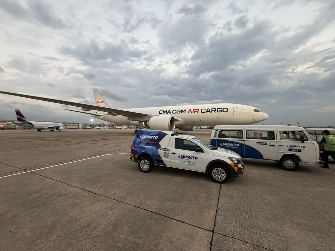 Vehículos de Impacto Aviation en la plataforma junto a una aeronave de carga CMA CGM Air Cargo
