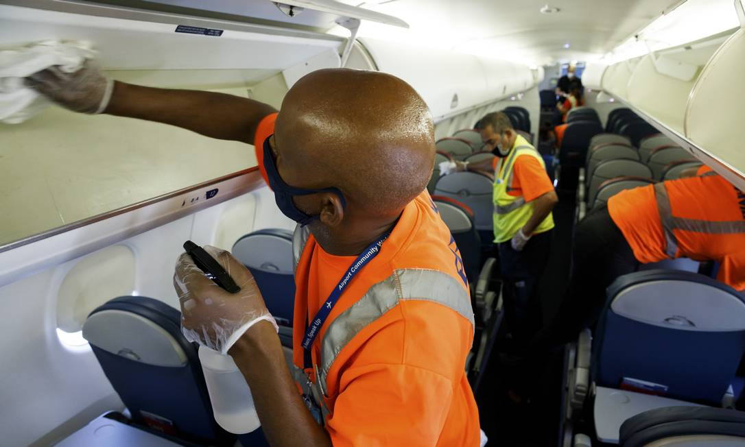 Technician sanitizing the overhead cabin compartment